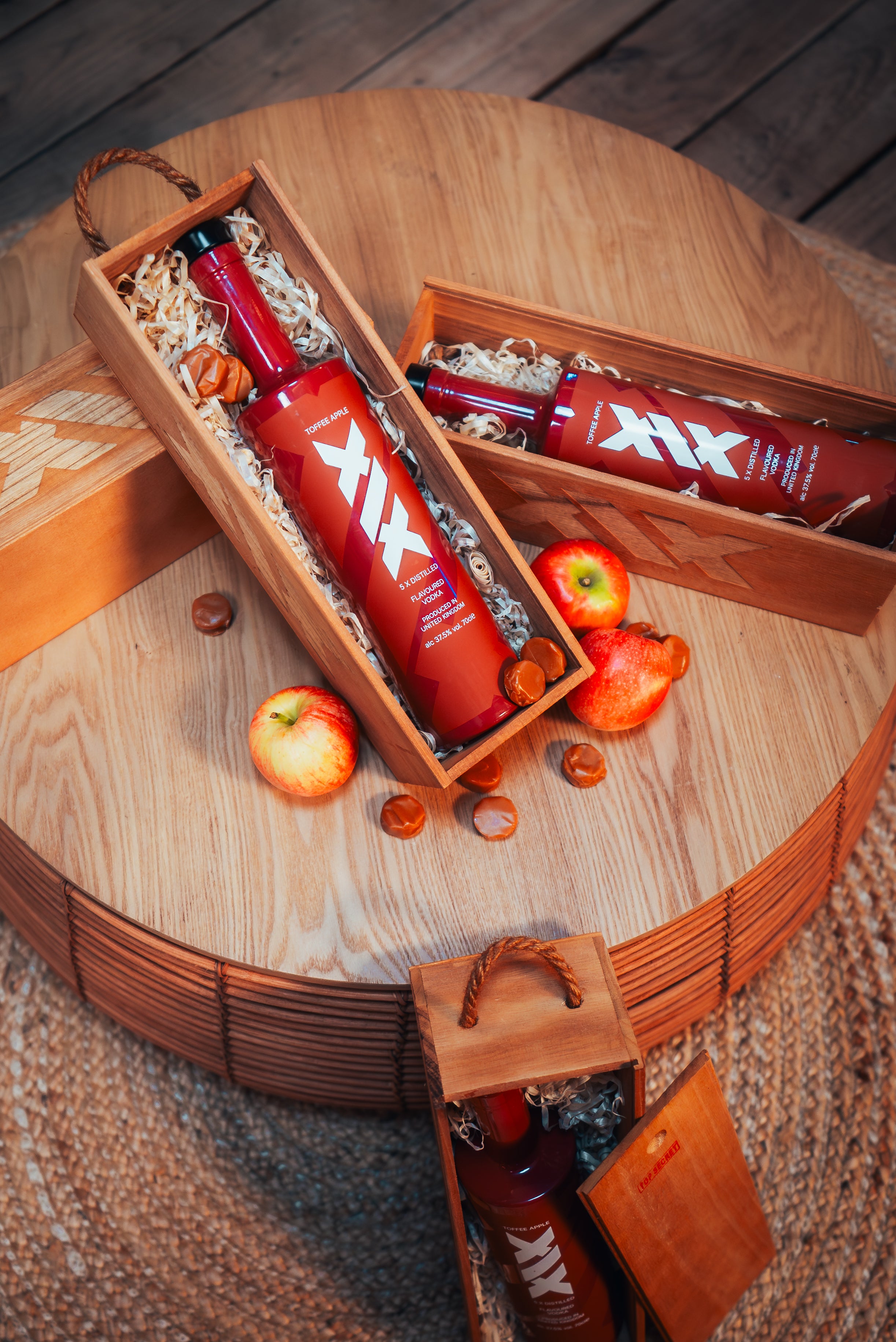 Brown bottles with 'XIX' branding in a wooden gift box on a wooden surface.