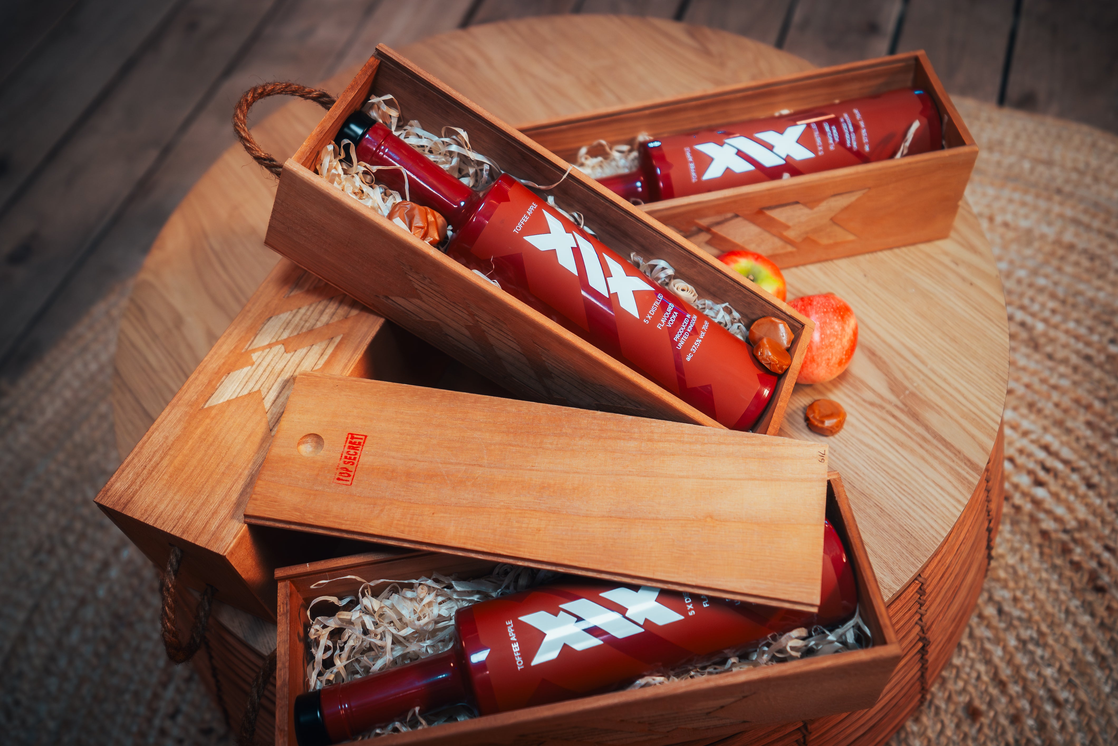 Brown bottles with white labels in a wooden gift box on a wooden surface