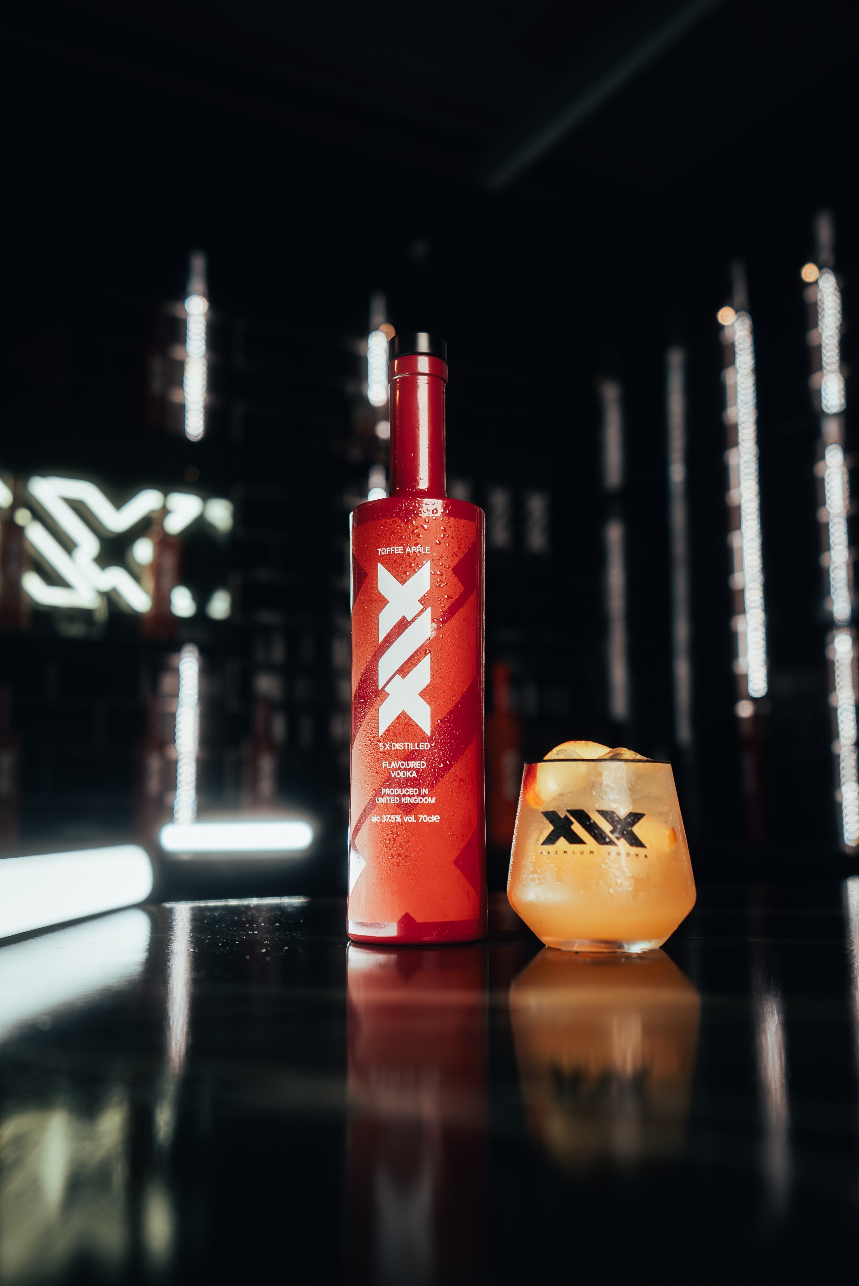 XIX bottle and glass with a drink on a dark background - the Toffee Apple Spritz